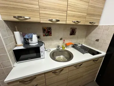 a kitchen counter with a sink and a microwave at Apartment Studio in Budva