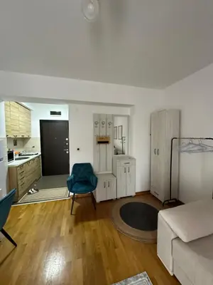 a living room with a couch and a blue chair at Apartment Studio in Budva