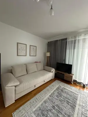 a living room with a white couch and a television at Apartment Studio in Budva