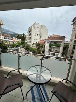 a table and chairs on a balcony with a view of a city at Apartment Studio in Budva
