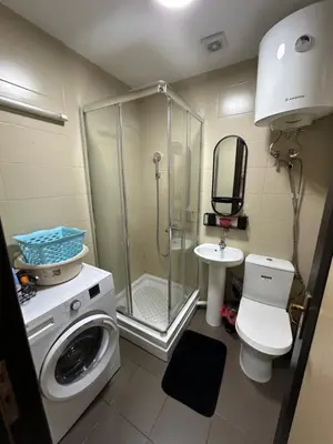 a bathroom with a shower and a washing machine at Apartment Studio in Budva