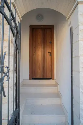 a hallway with a wooden door and stairs at Suite Apartment Sveti Stefan in Sveti Stefan