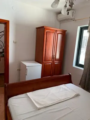 a bedroom with a bed with a cabinet and a mirror at Apartments Boffi in Ulcinj