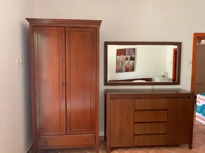a bathroom with a wooden cabinet and a mirror at Apartments Boffi in Ulcinj