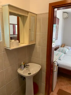 a bathroom with a sink and a bed at Apartments Boffi in Ulcinj