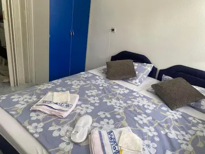 a bed with towels and shoes on top of it at Apartman Ema in Sutomore
