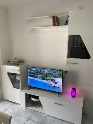 a white entertainment center with a flat screen tv at Apartman Ema in Sutomore