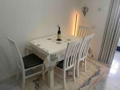 a white table with a bottle of wine on it at Apartman Ema in Sutomore