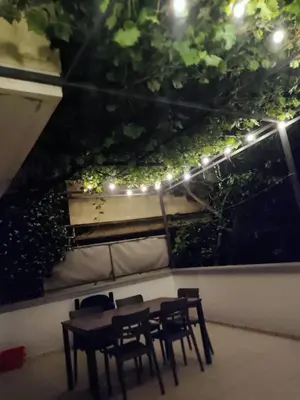 a table and chairs in a patio with lights at Una apartmani Petrovac in Petrovac na Moru