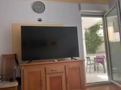 a flat screen tv sitting on top of a wooden entertainment center at Una apartmani Petrovac in Petrovac na Moru
