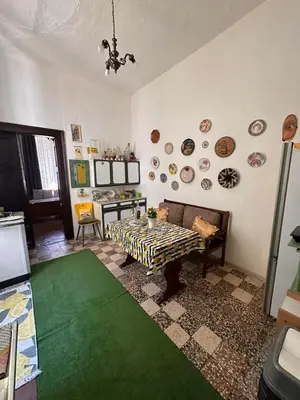 a living room with a table and a green rug at Old House in Cetinje