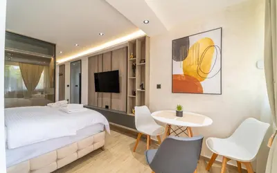 a bedroom with a bed and a table and chairs at ELIT APARTMENTS Budva in Budva
