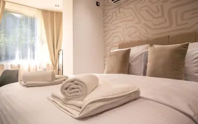 a white bed with towels on it with a window at ELIT APARTMENTS Budva in Budva