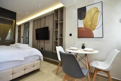 a bedroom with a bed and a table and chairs at ELIT APARTMENTS Budva in Budva