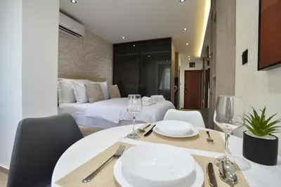 a dining room with a bed and a table and chairs at ELIT APARTMENTS Budva in Budva