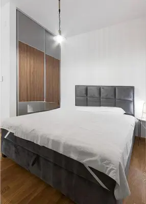 a bedroom with a large bed in a white room at Anja Apartment in Becici