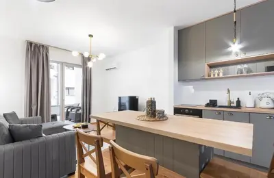 a kitchen and living room with a table and a couch at Anja Apartment in Becici