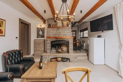 a living room with a fireplace and a tv at Villa Principium with Infinity Edge Pool&Hot Tub in Kotor