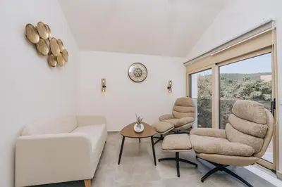 a living room with a couch and chairs and a window at Villa Principium with Infinity Edge Pool&Hot Tub in Kotor