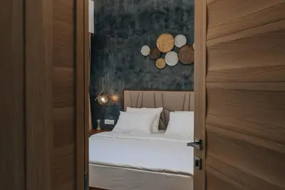 a bedroom with a bed with white pillows at Villa Principium with Infinity Edge Pool&Hot Tub in Kotor