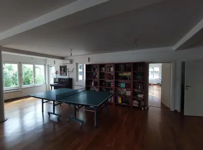 a living room with a ping pong table and book shelves at Fun and spacious apartment in Budva