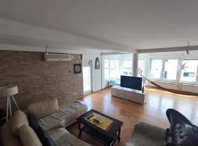 a living room with a couch and a tv at Fun and spacious apartment in Budva