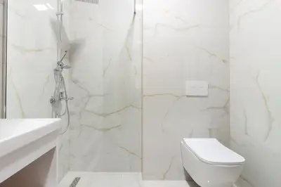 a white bathroom with a toilet and a shower at M&N Holiday Resort in Ulcinj