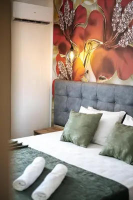 a bedroom with a bed with two pillows and a painting at M&N Holiday Resort in Ulcinj