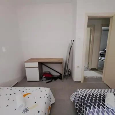 a bedroom with a bed and a desk and a table at Family house VND in Kotor