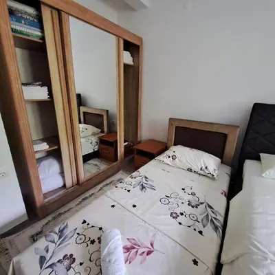 a small bedroom with a bed and a mirror at Family house VND in Kotor