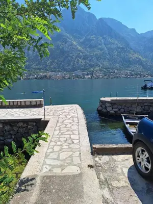 a car parked next to a body of water at Old stone house Danka in Kotor