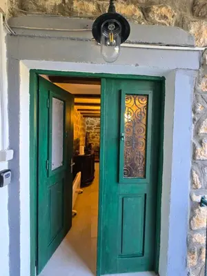 a green door in a room with a stone wall at Old stone house Danka in Kotor