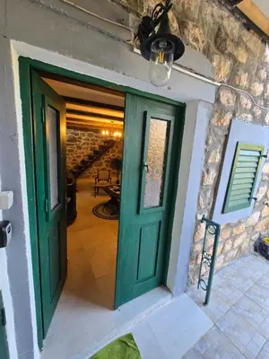 a green door in a stone building with a staircase at Old stone house Danka in Kotor