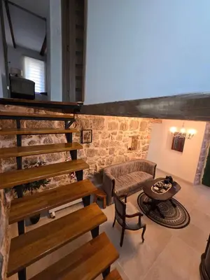 a living room with a staircase and a couch at Old stone house Danka in Kotor