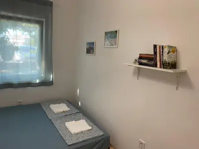a bedroom with a bed and a window and books at Deskos Cottage in Sutomore in Zgrada