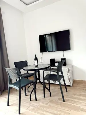 a dining room with a table and chairs and a flat screen tv at Blue Sutomore in Brca