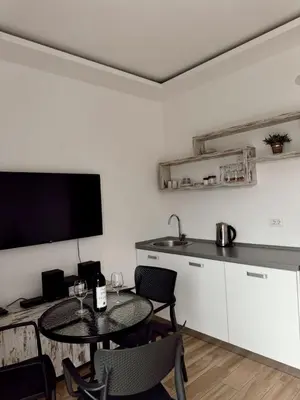 a living room with a table and chairs and a television at Blue Sutomore in Brca