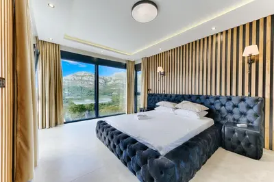 a bedroom with a large bed with a large window at Villa Monza in Bar