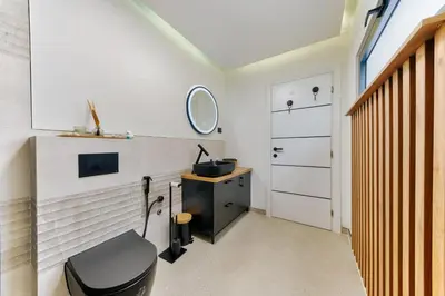 a bathroom with a black toilet and a sink at Villa Monza in Bar