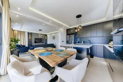 a kitchen and dining room with a wooden table and white chairs at Villa Monza in Bar