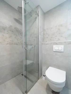 a bathroom with a toilet and a glass shower at Classy Two-Bedroom Apartment in Budva