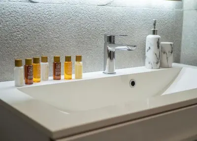 a white bathroom sink with bottles ofodorizers on it at Classy Two-Bedroom Apartment in Budva
