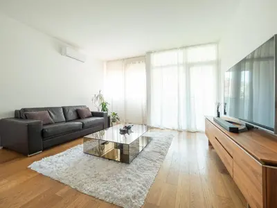 a living room with a couch and a glass coffee table at Classy Two-Bedroom Apartment in Budva
