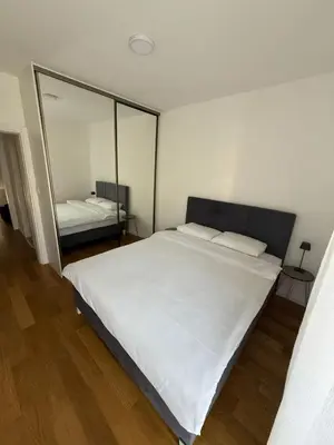 a bedroom with a large white bed and a mirror at Classy Two-Bedroom Apartment in Budva