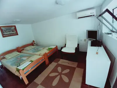 a bedroom with two beds and a desk and a television at Zagradge IN Apartments in Zagrađe