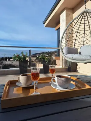 a tray with two cups and two wine glasses on a balcony at Villa Bartula Lux in Rap