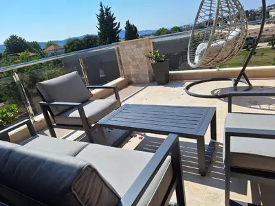 a patio with a table and chairs and a swing at Villa Bartula Lux in Rap