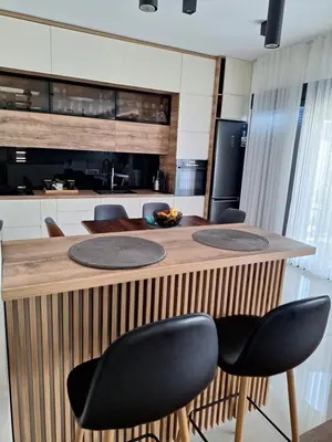 a kitchen with a wooden counter with black chairs at Villa Bartula Lux in Rap