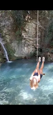 a woman on a rope swing in a river at Villa Bartula Lux in Rap