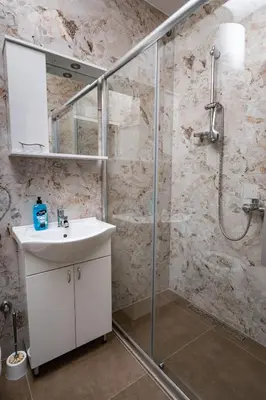 a bathroom with a sink and a shower at Apartmani Kaan in Podgorica